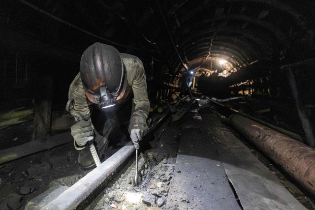 A Ukrainian miner clears a railway track at a depth of around 300 metres at a coal mine operated by Ukrainian energy provider DTEK at an undisclosed location in the Dnipropetrovsk region on May 5, 2026, amid the Russian invasion of Ukraine. (Photo by Serhii Okunev / AFP)