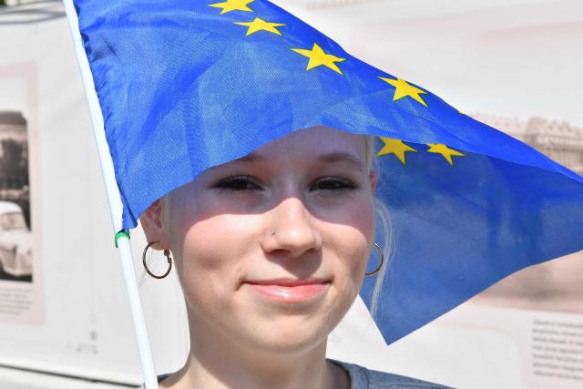 A woman holding a European Union flag celebrates outside Hungary's parliament building after the inauguration of the new Hungarian Prime Minister in Budapest on May 9, 2026. Lawmakers in Hungary on May 9, 2026 swore in pro-European conservative Peter Magyar as the country's new prime minister, after elections last month that ended Viktor Orban's 16 years in power. The parliament formally elected Magyar with 140 votes for, 54 against, and one abstention in the inaugural session of the new chamber resulting from the April polls. (Photo by Ferenc ISZA / AFP)