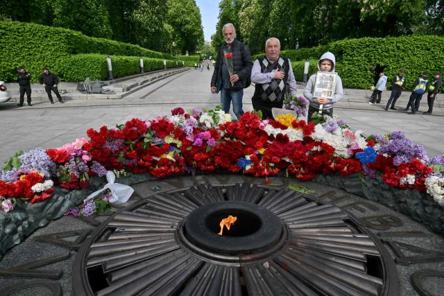 People lay flowers on the Tomb of the Unknown Soldier to mark the Victory Day over Nazism in World War II, at the Eternal Glory park in Kyiv on May 9, 2026, amid the Russian invasion of Ukraine. (Photo by Sergei SUPINSKY / AFP)