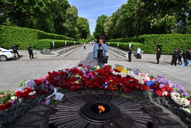A woman reacts as she lays flowers on the Tomb of the Unknown Soldier to mark the Victory Day over Nazism in World War II, at the Eternal Glory park in Kyiv on May 9, 2026, amid the Russian invasion of Ukraine. (Photo by Sergei SUPINSKY / AFP)