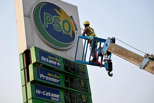 A filling station employee cleans a digital display showing updated fuel prices after a rise amid global energy crises due to the Middle East war, near a gas station in Islamabad on May 9, 2026. (Photo by Farooq NAEEM / AFP)