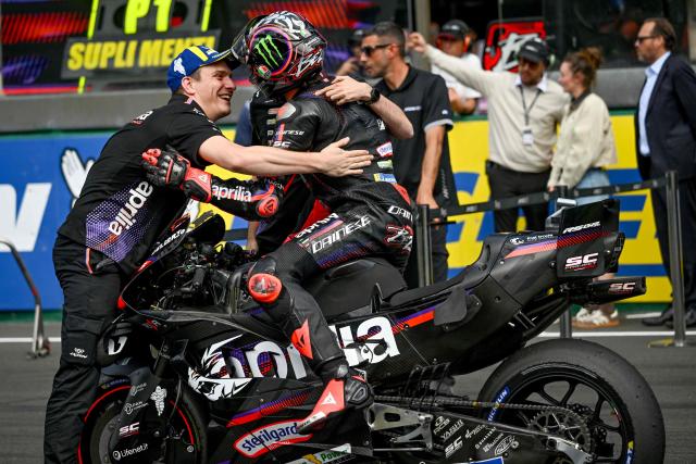 Aprilia Racing's Spanish rider Jorge Martin (C) is embraced by members of his team in parc ferme after winning the Moto GP Grand Prix of France Sprint race at Le Mans, northwestern France, on May 9, 2026. (Photo by Loic VENANCE / AFP)