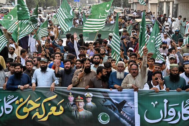 Pakistan Markazi Muslim League (PMML) activists hold a banner reading "Bunyan-um-Marsoos" as they march during a rally to mark one year since the India-Pakistan conflict, in Lahore on May 9, 2026. (Photo by Arif ALI / AFP)