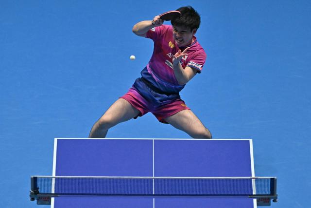 Japan's Tomokazu Harimoto returns to Taiwan's Lin Yun-ju during their Men's Teams semi-final match at the ITTF World Table Tennis Championships in Wembley Arena, west London on May 9, 2026. (Photo by Glyn KIRK / AFP)