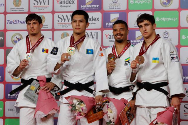 (L-R) Silver medallist Moldova's Petru Pelivan, gold medallist Kazakhstan's Zhalgas Kairolla, bronze medallists Brazil's David Lima and Ukraine's Vladyslav Kolobov celebrate during the medal ceremony for the men's under 81 kg event at the Astana Grand Slam judo tournament in Astana on May 9, 2026. (Photo by STANISLAV FILIPPOV / AFP)