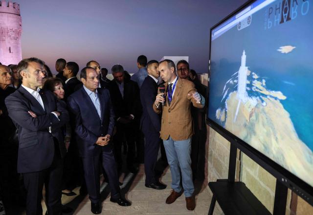 France's President Emmanuel Macron (L) and his Egyptian counterpart Abdel Fattah al-Sisi (C) watch a video on the history of the city during a visit to the Citadel of Qaitbay in Alexandria on May 9, 2026. Macron on May 9 embarked on a visit to Africa aimed at renewing France's engagement with the continent after years of strained ties with former French speaking colonies, also travelling to Egypt, Ethiopia and Kenya. (Photo by Ludovic MARIN / AFP)