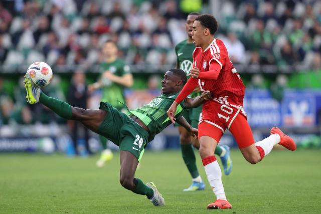 Wolfsburg's French defender #26 Sael Kumbedi (L) and Bayern Munich's German midfielder #10 Jamal Musiala vie for the ball during the German first division Bundesliga football match between VfL Wolfsburg and FC Bayern Munich in Wolfsburg, on May 9, 2026. (Photo by Ronny HARTMANN / AFP) / DFL REGULATIONS PROHIBIT ANY USE OF PHOTOGRAPHS AS IMAGE SEQUENCES AND/OR QUASI-VIDEO