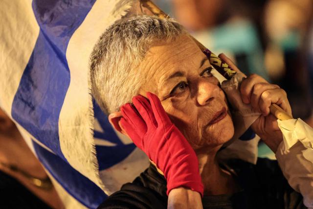 An Israeli left-wing activist wears a red glove during a rally in Tel Aviv's HaBima Square against the ongoing war with Iran and against the Israeli government on May 9, 2026. The war, launched by the United States and Israel in late February, has seen Iran respond with attacks across the Middle East and impose a chokehold on the Strait of Hormuz, the gateway to the Gulf oil and gas industries and a strategic trade route. (Photo by Jack GUEZ / AFP) / 