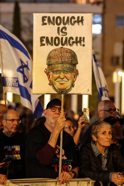 An Israeli left-wing activist holds up a placard during a demonstration in Tel Aviv's HaBima Square against the ongoing war with Iran and against the Israeli government on May 9, 2026. The war, launched by the United States and Israel in late February, has seen Iran respond with attacks across the Middle East and impose a chokehold on the Strait of Hormuz, the gateway to the Gulf oil and gas industries and a strategic trade route. (Photo by Jack GUEZ / AFP) / 