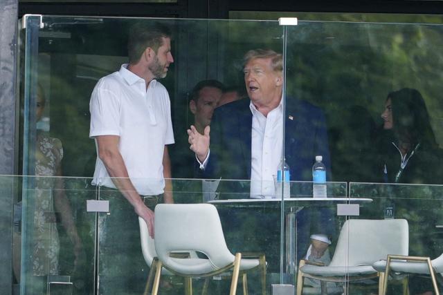 US President Donald Trump speaks with his son Eric trump as he attends the LIV Golf Virginia 2026 tournament at Trump National Golf Club in Sterling, Virginia on May 9, 2026. (Photo by Aaron Schwartz / AFP)