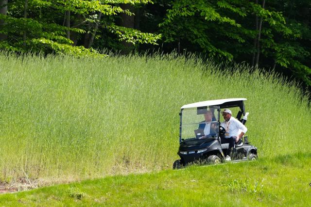 US President Donald Trump is seen in a golf cart as he arrives at the LIV Golf Virginia 2026 tournament at Trump National Golf Club in Sterling, Virginia on May 9, 2026. (Photo by Aaron Schwartz / AFP)