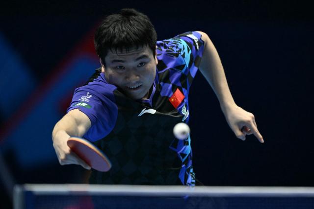 China's Liang Jingkun returns to France's Alexis Lebrun during their Men's Teams semi-final match at the ITTF World Table Tennis Championships in Wembley Arena, west London on May 9, 2026. (Photo by Glyn KIRK / AFP)