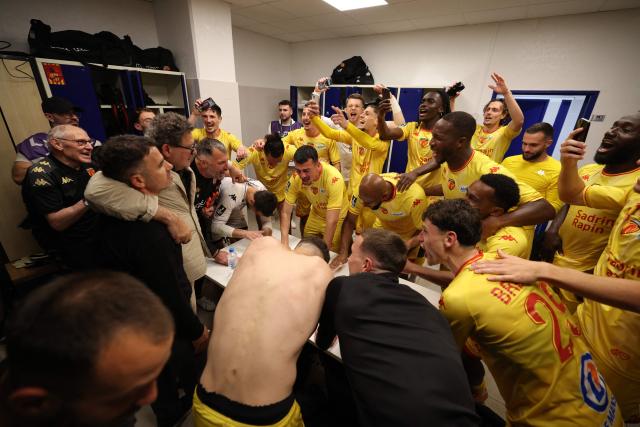 Le Mans' players and staff celebrate after winning the French L2 football match between Bastia and Le Mans at the Armand-Cesari stadium, in Bastia, on the French Mediterranean island of Corsica on May 9, 2026. Following Troyes' promotion as Ligue 2 champions, there is just one direct promotion spot left to be claimed by three clubs – Le Mans, Saint-Etienne and Red Star – on the 34th and final matchday in the evening of May 9, 2026. (Photo by Pascal POCHARD-CASABIANCA / AFP)