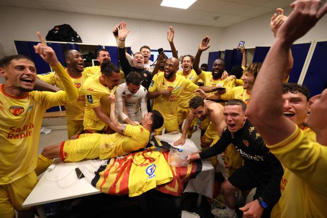 Le Mans' players and staff celebrate after winning the French L2 football match between Bastia and Le Mans at the Armand-Cesari stadium, in Bastia, on the French Mediterranean island of Corsica on May 9, 2026. Following Troyes' promotion as Ligue 2 champions, there is just one direct promotion spot left to be claimed by three clubs – Le Mans, Saint-Etienne and Red Star – on the 34th and final matchday in the evening of May 9, 2026. (Photo by Pascal POCHARD-CASABIANCA / AFP)