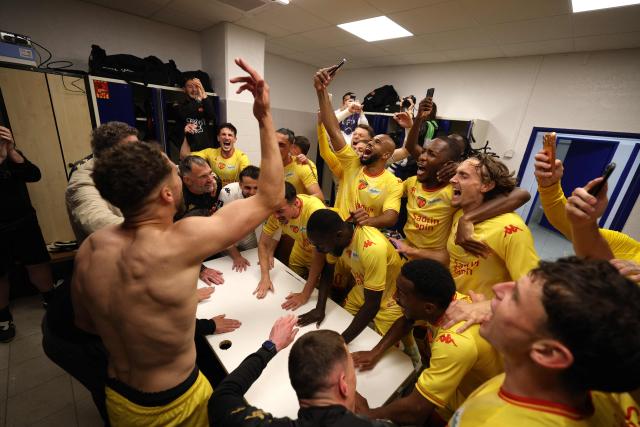 Le Mans' players and staff celebrate after winning the French L2 football match between Bastia and Le Mans at the Armand-Cesari stadium, in Bastia, on the French Mediterranean island of Corsica on May 9, 2026. Following Troyes' promotion as Ligue 2 champions, there is just one direct promotion spot left to be claimed by three clubs – Le Mans, Saint-Etienne and Red Star – on the 34th and final matchday in the evening of May 9, 2026. (Photo by Pascal POCHARD-CASABIANCA / AFP)