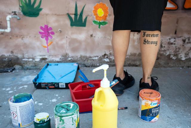 A migrant mother paints a mural as part of mother's Day celebrations at Comunidad de Luz shelter in Tijuana, Baja California state, Mexico on May 9, 2026. (Photo by Guillermo Arias / AFP)