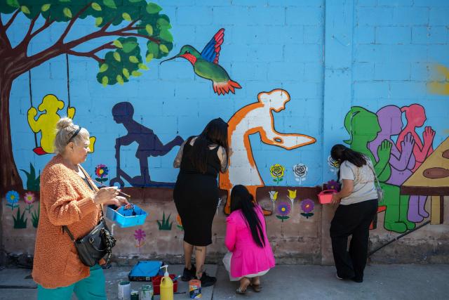 Migrants paint a mural as part of mother's Day celebrations for migrant mothers at Comunidad de Luz shelter in Tijuana, Baja California state, Mexico on May 9, 2026. (Photo by Guillermo Arias / AFP)