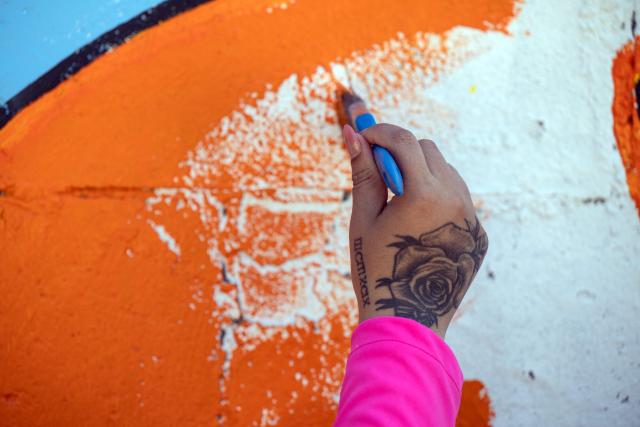 A migrant mother paints a mural as part of mother's Day celebrations at Comunidad de Luz shelter in Tijuana, Baja California state, Mexico on May 9, 2026. (Photo by Guillermo Arias / AFP)