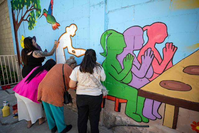 Migrants paint a mural as part of mother's Day celebrations at Comunidad de Luz shelter in Tijuana, Baja California state, Mexico on May 9, 2026. (Photo by Guillermo Arias / AFP)