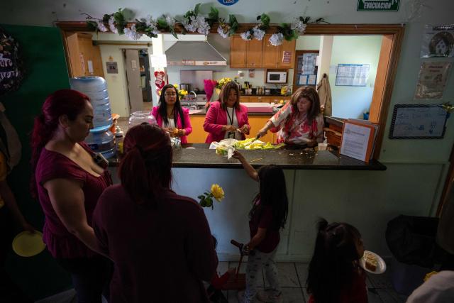 Migrant mothers receive flowes and a piece of cake as part of mother's Day celebrations at Comunidad de Luz shelter in Tijuana, Baja California state, Mexico on May 9, 2026. (Photo by Guillermo Arias / AFP)