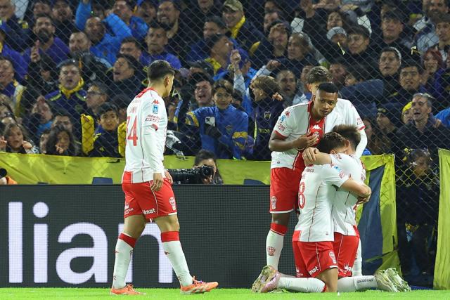 Huracan's midfielder #08 Leonardo Gil celebrates with teammates after scoring the opening goal during the Argentine Professional Football League 2026 Apertura Tournament round of 16 match between Boca Juniors and Huracan at La Bombonera Stadium in Buenos Aires on May 9, 2026. (Photo by Alejandro PAGNI / AFP)