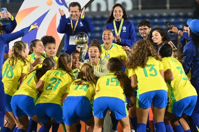 Brazil's head coach Rilany Aguiar lifts the trophy with her players after winning the Conmebol Women U-17 final football match between Brazil and Argentina at the Defensores del Chaco stadium in Asuncion on May 9, 2026. (Photo by DANIEL DUARTE / AFP)