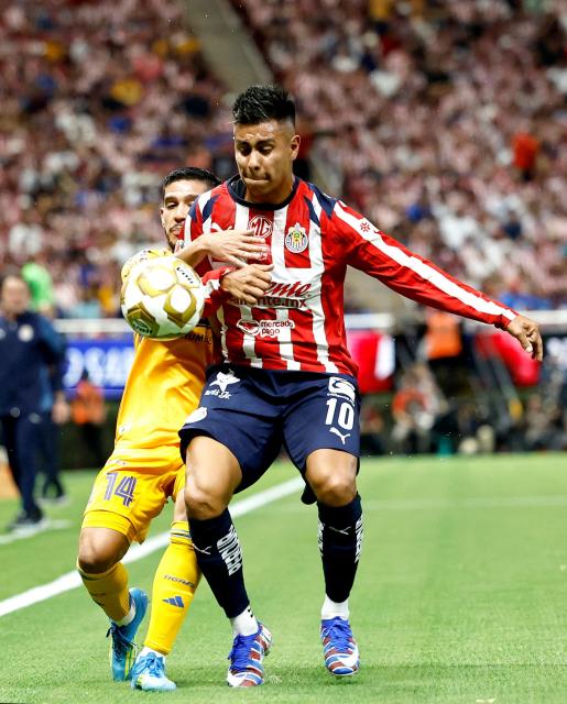 Guadalajara's forward #10 Efrain Alvarez (R) and Tigres' midfielder #14 Jesus Garza fight for the ball during the Liga MX Clausura quarter-finals second leg football match between Guadalajara and Tigres at Akron Stadium in Guadalajara, Jalisco state, Mexico on May 9, 2026. (Photo by ULISES RUIZ / AFP)
