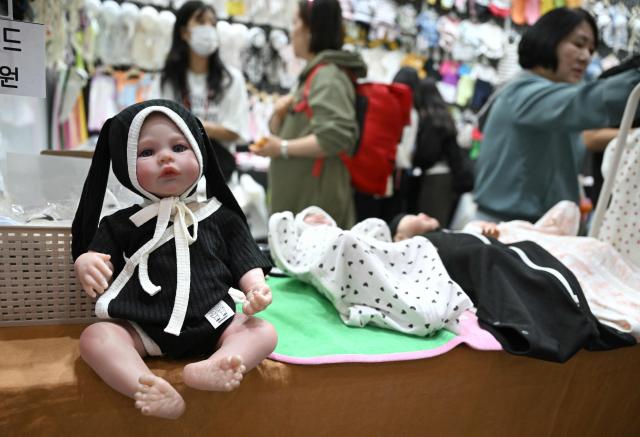 This picture taken on April 30, 2026 shows baby clothes displayed at a booth during a baby fair in Seoul. South Korea has one of the world's lowest birth rates, and the government has spent billions of dollars trying to encourage citizens to have more babies and cushion the worst impacts of a shrinking population. The Asian nation is still nowhere near reversing the trend, but a modest baby bump is offering a glimmer of hope after years of bleak statistics. (Photo by Jung Yeon-je / AFP) / TO GO WITH AFP STORY  SKorea-demographics / FOCUS BY Matthew Walsh and Jihye Shin