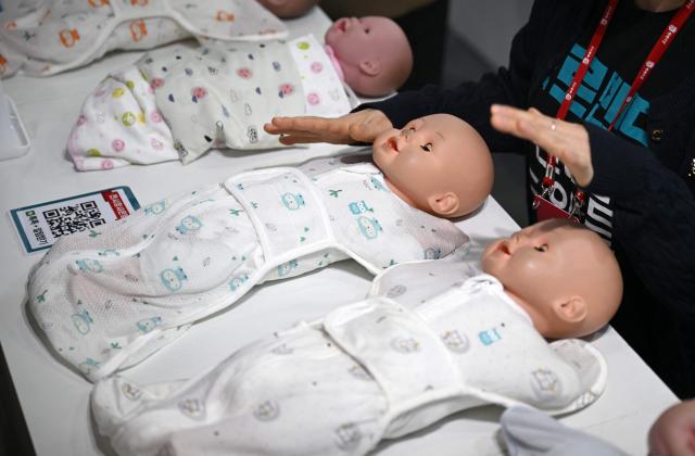 This picture taken on April 30, 2026 shows swaddles wrapping baby dolls displayed at a booth during a baby fair in Seoul. South Korea has one of the world's lowest birth rates, and the government has spent billions of dollars trying to encourage citizens to have more babies and cushion the worst impacts of a shrinking population. The Asian nation is still nowhere near reversing the trend, but a modest baby bump is offering a glimmer of hope after years of bleak statistics. (Photo by Jung Yeon-je / AFP) / TO GO WITH AFP STORY  SKorea-demographics / FOCUS BY Matthew Walsh and Jihye Shin