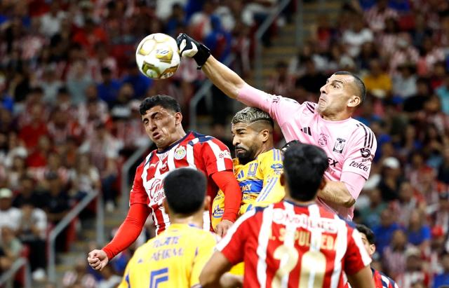 Tigres' Argentine goalkeeper #01 Nahuel Guzman clears the ball next to teammate Uruguayan forward #17 Rodrigo Aguirre and Guadalajara's defender #05 Bryan Gonzalez fight for the ball during the Liga MX Clausura quarter-finals second leg football match between Guadalajara and Tigres at Akron Stadium in Guadalajara, Jalisco state, Mexico on May 9, 2026. (Photo by ULISES RUIZ / AFP)
