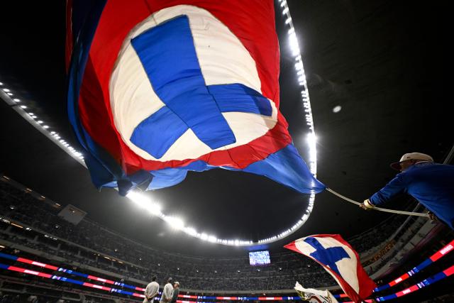 A fan of Cruz Azul waves a flag with the team's logo ahead of the Liga MX Clausura quarter-finals second leg football match between Cruz Azul and Atlas at Banorte Stadium in Mexico City on May 9, 2026. (Photo by Alfredo ESTRELLA / AFP)