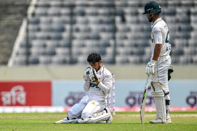 Pakistan's Azan Awais (L) prays after scoring a century (100 runs) as his teammate Abdullah Fazal watches during the third day of the first Test cricket match between Bangladesh and Pakistan at the Sher-e-Bangla National Stadium in Mirpur on May 10, 2026. (Photo by Munir UZ ZAMAN / AFP)