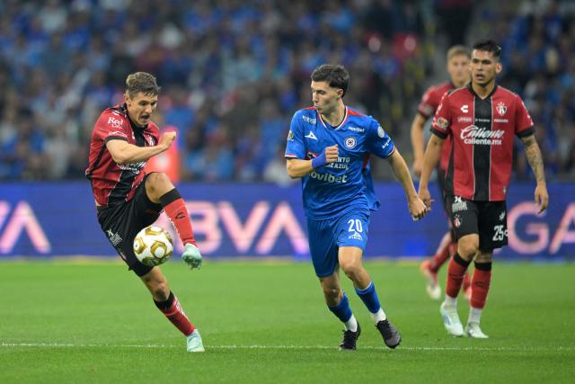 Atlas' Argentine defender #21 Rodrigo Schlegel (L) controls the ball past Cruz Azul's Argentine forward #20 Jose Paradela (C) during the Liga MX Clausura quarter-finals second leg football match between Cruz Azul and Atlas at Banorte Stadium in Mexico City on May 9, 2026. (Photo by Alfredo ESTRELLA / AFP)