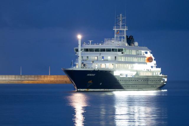 The Dutch-flagged hantavirus-stricken cruise ship MV Hondius anchors at the industrial port of Granadilla de Abona, Tenerife, in the Canary Islands, Spain early on May 10, 2026. A cruise ship hit with a deadly hantavirus outbreak is headed for Spain's Canary Islands, where most of the nearly 150 people on board will be evacuated and flown home after weeks at sea. The Dutch-flagged MV Hondius is expected to reach waters off the industrial port of Granadilla de Abona in Tenerife at dawn on May 10, 2026, where WHO chief Tedros Adhanom Ghebreyesus is due to help coordinate the ship's evacuation. (Photo by Jorge GUERRERO / AFP)
