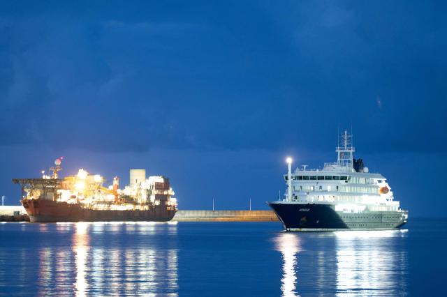 The Dutch-flagged hantavirus-stricken cruise ship MV Hondius anchors at the industrial port of Granadilla de Abona, Tenerife, in the Canary Islands, Spain early on May 10, 2026. A cruise ship hit with a deadly hantavirus outbreak is headed for Spain's Canary Islands, where most of the nearly 150 people on board will be evacuated and flown home after weeks at sea. The Dutch-flagged MV Hondius is expected to reach waters off the industrial port of Granadilla de Abona in Tenerife at dawn on May 10, 2026, where WHO chief Tedros Adhanom Ghebreyesus is due to help coordinate the ship's evacuation. (Photo by JORGE GUERRERO / AFP)