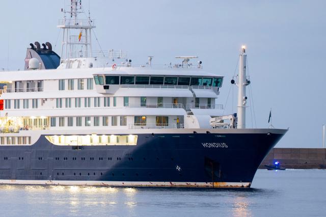 The Dutch flagged hantavirus-stricken cruise ship MV Hondius arrives to the industrial port of Granadilla de Abona on the island of Tenerife in Spain's Canary Islands to commence evacuation of passengers and most crew members on May 10, 2026. Repatriation flights for the nearly 150 passengers onboard the ship hit by a deadly hantavirus outbreak are planned to the United States, Britain, France,  and other countries, Spain's interior minister announced on Saturday.  Passengers will be transferred to shore on a smaller vessel then by bus to the airport and then flown home after weeks at sea. (Photo by JORGE GUERRERO / AFP)