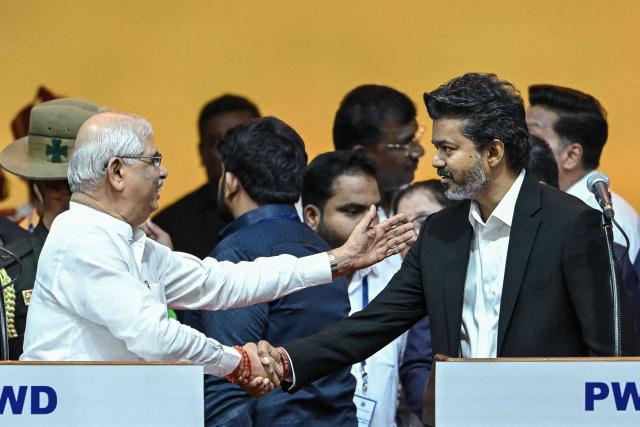 Newly elected chief minister of India's Tamil Nadu state, C. Joseph Vijay (R) shaking hands with Governor Rajendra Vishwanath Arlekar (L) after taking the oath during his swearing-in ceremony in Chennai on May 10, 2026. Indian film superstar C. Joseph Vijay was on May 10 sworn in as chief minister of Tamil Nadu state, after his party emerged as the single largest following elections in the industrial hub. (Photo by R.Satish BABU / AFP)