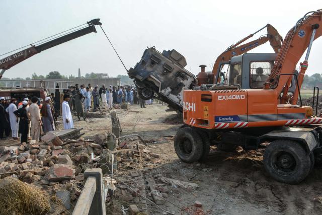 A crane removes a burned armored vehicle from a damaged police checkpost site following a car bombing attack by militants in the Fateh Khel area of Pakistan's Bannu on May 10, 2026. Militants detonated a car bomb at a checkpoint in northwestern Pakistan and opened fire on police, killing at least 12 and wounding five, officials said on May 10. (Photo by Karim ULLAH / AFP)