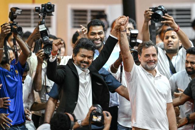 Newly elected chief minister of India's Tamil Nadu state, C. Joseph Vijay (L, front) along with Indian National Congress (INC) party leader Rahul Gandhi (R, front) reacts after taking the oath during his swearing-in ceremony in Chennai on May 10, 2026. (Photo by R.Satish BABU / AFP)