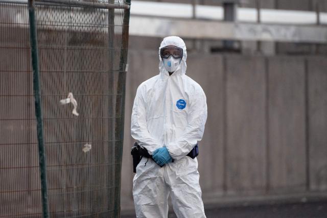 A Spanish civil guard wears a protective suit in as the Dutch flagged hantavirus-stricken cruise ship MV Hondius arrived at the industrial port of Granadilla de Abona on the island of Tenerife in Spain's Canary Islands on May 10, 2026. Repatriation flights for the nearly 150 passengers onboard the ship hit by a deadly hantavirus outbreak are planned to the United States, Britain, France,  and other countries, Spain's interior minister announced on Saturday. Most of the nearly 150 people on board will be transferred to shore on smaller vessels then by bus to the airport and then flown home after weeks at sea. (Photo by JORGE GUERRERO / AFP)