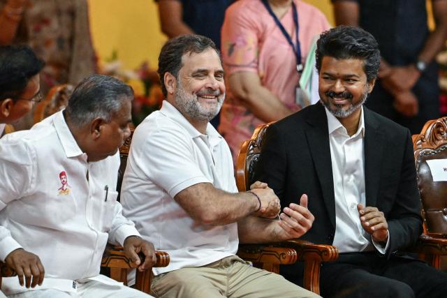 Newly elected chief minister of India's Tamil Nadu state, C. Joseph Vijay (R) greets Indian National Congress (INC) party leader Rahul Gandhi (C) after taking the oath during his swearing-in ceremony in Chennai on May 10, 2026. (Photo by R.Satish BABU / AFP)