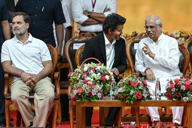 Newly elected chief minister of India's Tamil Nadu state, C. Joseph Vijay (C) speaks with Governor Rajendra Vishwanath Arlekar (R) as Indian National Congress (INC) party leader Rahul Gandhi (L) sits beside him during his swearing-in ceremony in Chennai on May 10, 2026. Indian film superstar C. Joseph Vijay was on May 10 sworn in as chief minister of Tamil Nadu state, after his party emerged as the single largest following elections in the industrial hub. (Photo by R.Satish BABU / AFP)