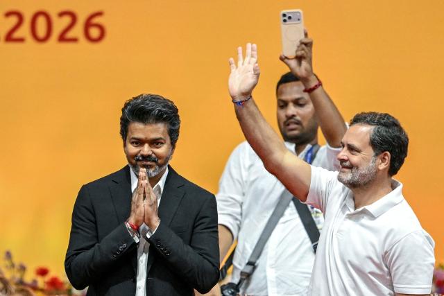 Newly elected chief minister of India's Tamil Nadu state, C. Joseph Vijay (L) along with Indian National Congress (INC) party leader Rahul Gandhi (R) greets supporters after taking the oath during his swearing-in ceremony in Chennai on May 10, 2026. (Photo by R.Satish BABU / AFP)