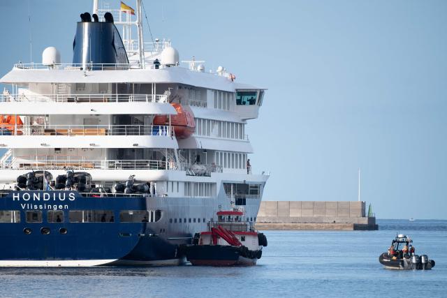 Boats approach the Dutch flagged hantavirus-stricken cruise ship MV Hondius after it arrived at the industrial port of Granadilla de Abona on the island of Tenerife in Spain's Canary Islands on May 10, 2026. Repatriation flights for the nearly 150 passengers onboard the ship hit by a deadly hantavirus outbreak are planned to the United States, Britain, France,  and other countries, Spain's interior minister announced on Saturday. Most of the nearly 150 people on board will be transferred to shore on smaller vessels then by bus to the airport and then flown home after weeks at sea. (Photo by JORGE GUERRERO / AFP)