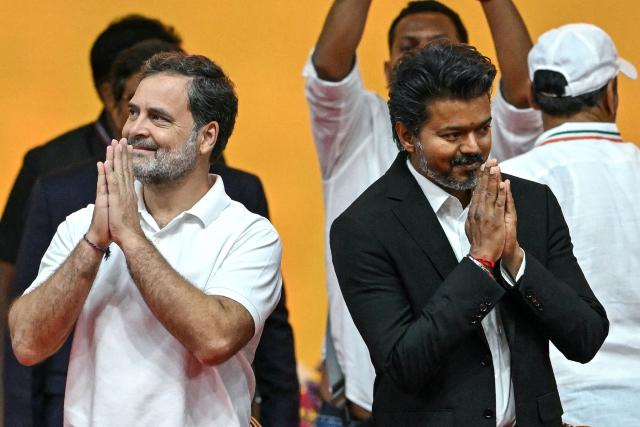 Newly elected chief minister of India's Tamil Nadu state, C. Joseph Vijay (R) along with Indian National Congress (INC) party leader Rahul Gandhi greets supporters before taking the oath during his swearing-in ceremony in Chennai on May 10, 2026. (Photo by R.Satish BABU / AFP)