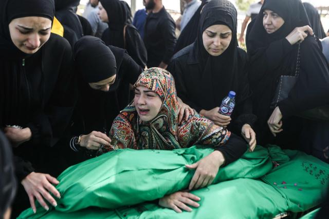 Lebanese women grieve over the bodies of nine people killed the day before in an Israeli airstrike on the southern Lebanese village of Jibshit, during their funeral in the city of Sidon on May 10, 2026. Israel carried out strikes across Lebanon on May 9, 2026, killing at least nine people, in the south according to authorities, with raids also targeting a highway not far from Beirut outside of Hezbollah's traditional strongholds. Lebanon was drawn into the Middle East war on March 2 when Tehran-backed militant group Hezbollah launched attacks on Israel to avenge the killing of the Iranian leader. Israel has responded with broad strikes across Lebanon and a ground offencive. (Photo by MAHMOUD ZAYYAT / AFP)