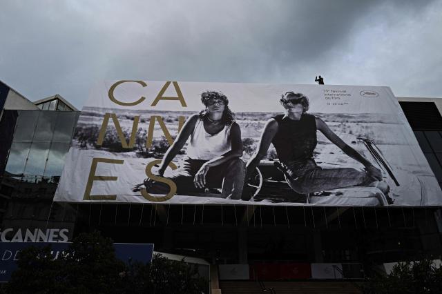 A worker hangs the official poster of the 78th Cannes Film Festival on the facade of the Palais des Festivals in Cannes, south-eastern France on May 10, 2026. The Cannes Film festival will take place from May 12 to May 23, 2026. (Photo by Valery HACHE / AFP)