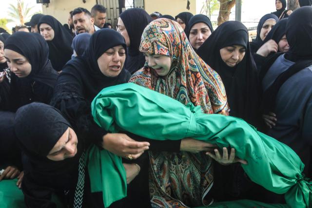 A Lebanese woman reacts as she grieves over the body of one of the nine people killed the day before in an Israeli airstrike on the southern Lebanese village of Jibshit, during their funeral in the city of Sidon on May 10, 2026. Israel carried out strikes across Lebanon on May 9, 2026, killing at least nine people, in the south according to authorities, with raids also targeting a highway not far from Beirut outside of Hezbollah's traditional strongholds. Lebanon was drawn into the Middle East war on March 2 when Tehran-backed militant group Hezbollah launched attacks on Israel to avenge the killing of the Iranian leader. Israel has responded with broad strikes across Lebanon and a ground offencive. (Photo by Mahmoud ZAYYAT / AFP)