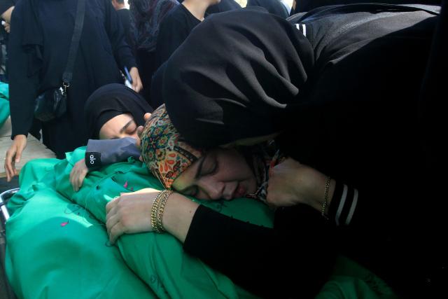 Lebanese women grieve over the bodies of nine people killed the day before in an Israeli airstrike on the southern Lebanese village of Jibshit, during their funeral in the city of Sidon on May 10, 2026. Israel carried out strikes across Lebanon on May 9, 2026, killing at least nine people, in the south according to authorities, with raids also targeting a highway not far from Beirut outside of Hezbollah's traditional strongholds. Lebanon was drawn into the Middle East war on March 2 when Tehran-backed militant group Hezbollah launched attacks on Israel to avenge the killing of the Iranian leader. Israel has responded with broad strikes across Lebanon and a ground offencive. (Photo by Mahmoud ZAYYAT / AFP)