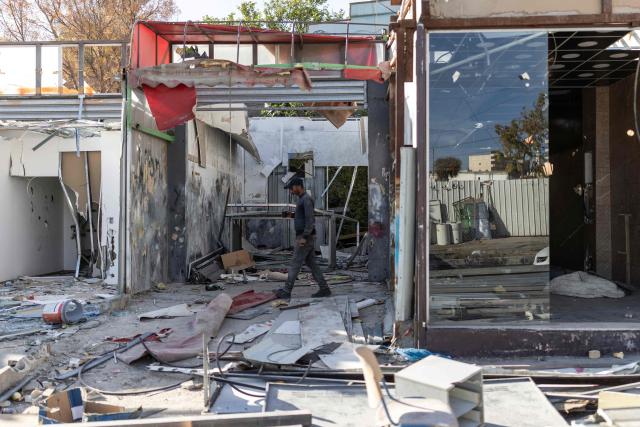 A Palestinian worker walks past shops he has demolished, ahead of the arrival of an Israeli army demolition team, in the Israeli-occupied Palestinian West Bank town of al-Eizariya, bordering East Jerusalem on May 10, 2026. Israel has a policy of demolishing the homes of Palestinians accused of deadly attacks against Israelis, saying it acts as a deterrent, as well as structures that Israel says are built without a licence. (Photo by ilia YEFIMOVICH / AFP)